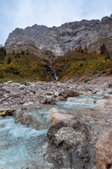 Clear mountain stream and waterfall at Großer Ahornboden in the Karwendel Mountains, Austria – crystal water flowing over rocks with dramatic alpine cliffs