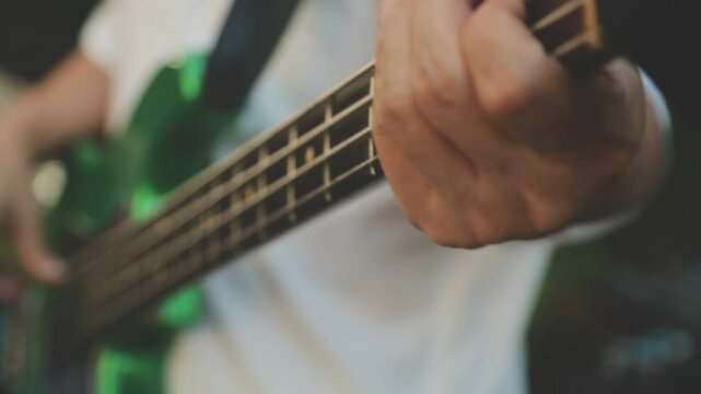 Hispanic man playing electric guitar in a music studio.