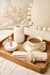 Cozy morning self-care setup with coffee cup, dried flowers and candle on wooden tray - horizontal