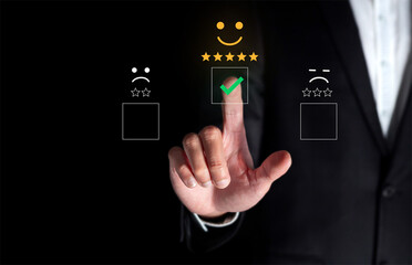 Hand touching and doing mark to select smiley face icon for evaluate product and service, customer satisfaction concept.