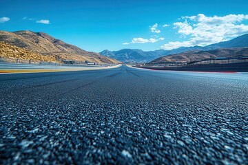 empty motor sport asphalt racetrack stretching into the distance pristine and clear awaiting the thrill of highspeed action with vivid blue skies overhead