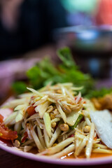 Green papaya salad in Thai cuisine is known as SOM TAM and is both spicy and delicious. Selective focus