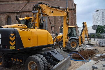 Wheeled excavators working together at an urban construction site