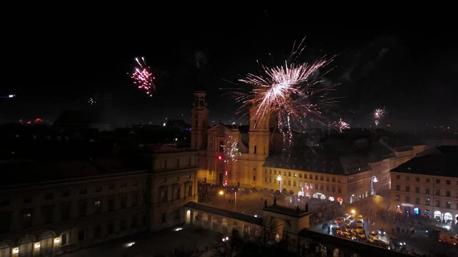 Aerial view at midnight of fireworks rockets and firecrackers in downtown Munich, Germany at Odeonplatz. Feldherrnhalle and Theatinerkirche in salute. Silvester Feuerwerk uber Munchen Luftaufnahme. 