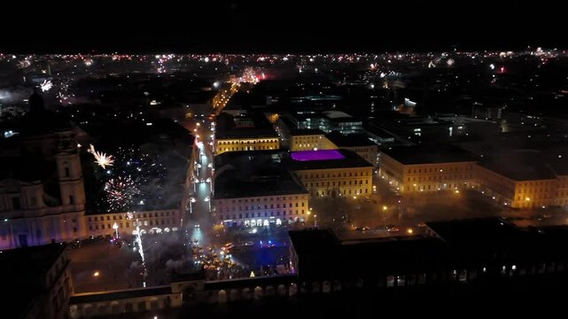 Aerial shot at midnight of fireworks and firecrackers lighting up downtown Munich, Germany, Odeonplatz. Feldherrnhalle and Theatinerkirche stand as part of festive scene. Silvester Feuerwerk Muenchen