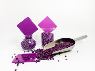 masterbacth plastic, purple masterbacth granules in glass container with chips, isolated on white...