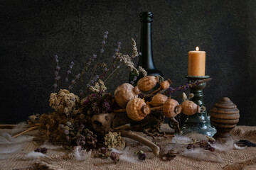 Still life. Background. Phyto composition. Desktop screensaver. Phyto design. Poppy fruits. Poppy heads. Dry flowers. Medicinal plants. Wild flowers. A candle is burning.