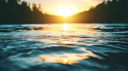 River water reflecting sun at sunset with blurred trees in the background.
