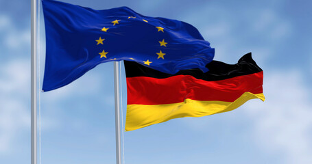 Flags of Germany and the European Union waving in the wind on a clear day