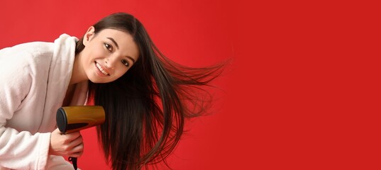 Beautiful young woman with hair dryer on red background with space for text