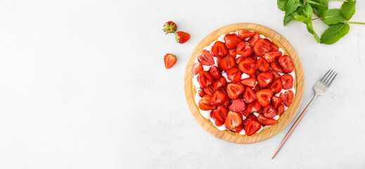 Wooden board with tasty strawberry pie on light background