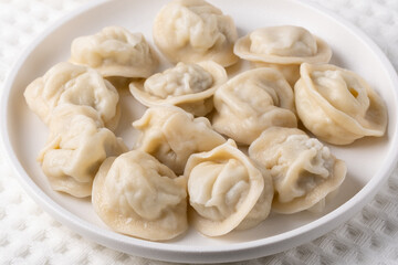 Traditional pelmeni, ravioli, dumplings filled with meat on plate, russian kitchen