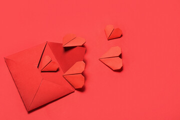 Composition with envelope and paper hearts on red background. Valentine's Day celebration