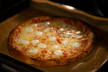 View of pizza with cheese baking in the oven