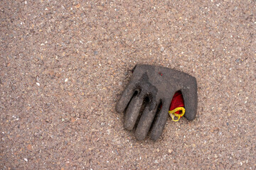 View of a dirty work glove lying on the asphalt