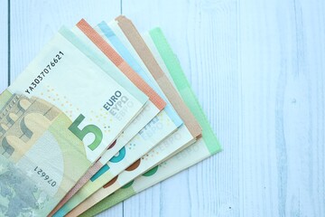 Big amount of different denominations of euro money bills on wooden background