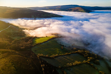 Drone view of fog and farmland in late afternoon sunlight