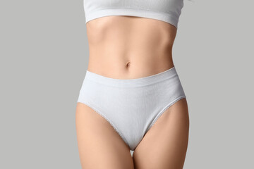 Fototapeta premium Beautiful young woman in white underwear on grey background, closeup