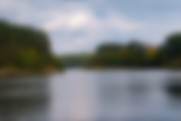Blurred image of green forest and wide river.jpg