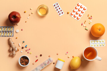Frame made of different pills, fruits, tea and honey on beige background. Immunity boosting concept
