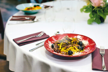 Pappardelle with meat, black olives, parmesan and garlic, Italian cuisine, Italian recipes, restaurant food