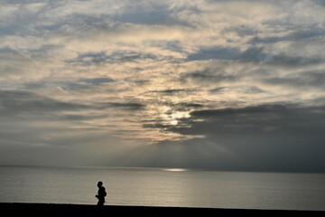 jogger silhouette running along the coast near sunset