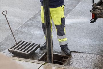 Arbeiter reinigt die Straßenkanalisatio