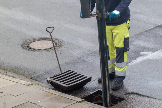 Arbeiter reinigt die Stra&szlig;enkanalisation