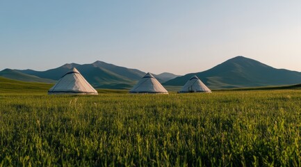 Fototapeta premium 草原に立ち並ぶ三つのゲルと壮大な山々の美しい風景