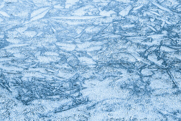 Shapes on the frozen surface of the lake in the winter with low temperatures in light blue color