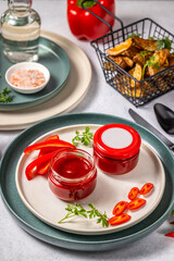 Two jars of red hot chili pepper sauce with blank label on a plate