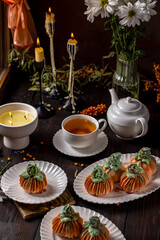 Pumpkin shaped desserts with tea and candles creating cozy autumn atmosphere