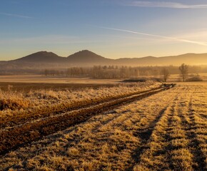 Sunrise in Rudawy Janowickie. View of Rudawy Janowickie. Frozen field at sunrise