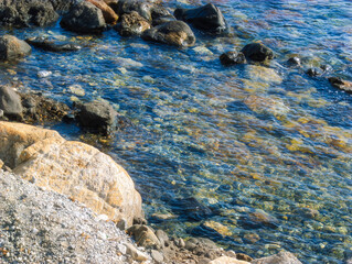 Clear blue Mediterranean waters with colorful stones along the coastline.. A natural and serene marine environment. Sicily, Italy. Copy cpace