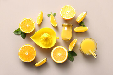 Glass and bottle of fresh orange juice with mint on light background