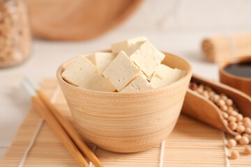 Bowl with pieces of tofu cheese on white background, closeup