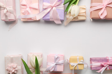 Frame made of gift boxes with tulips on white background. Happy Women's Day