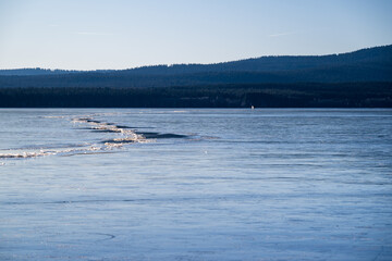 Winter sunny day at a frozen lake with ice floes