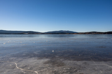 Winter sunny day at a frozen lake with ice floes