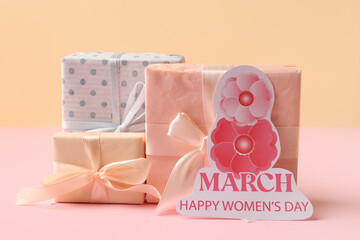 Festive postcard with gift boxes on color background. Happy Women's Day