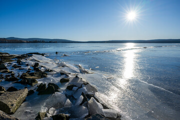Winter sunny day at a frozen lake with ice floes