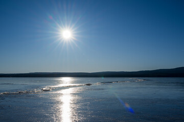 Winter sunny day at a frozen lake with ice floes