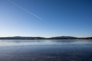Winter sunny day at a frozen lake with ice floes