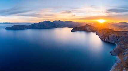 Fototapeta premium Breathtaking panoramic view of a serene coastal landscape at sunrise, with calm waters and majestic mountains under a stunning sky, capturing the essence of natural beauty and tran