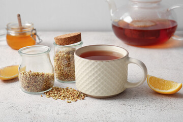 Cup of hot buckwheat tea with lemon on white background
