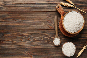 Bowls and spoon of raw rice with wheat on wooden background