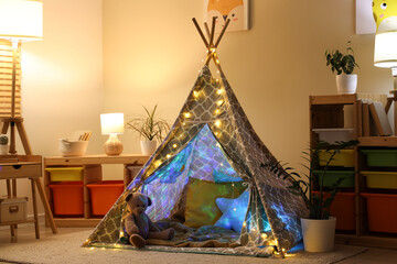 Interior of children's room with play tent and glowing lamps at night