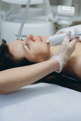 Professional cosmetologist performing LPG facial skin massage for rejuvenation in beauty salon.
