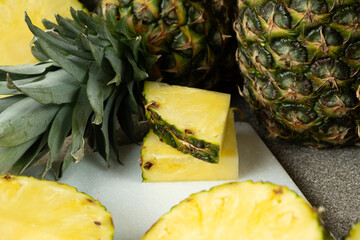 Pineapple background - whole fruit pineapples and cut into pieces and rings.