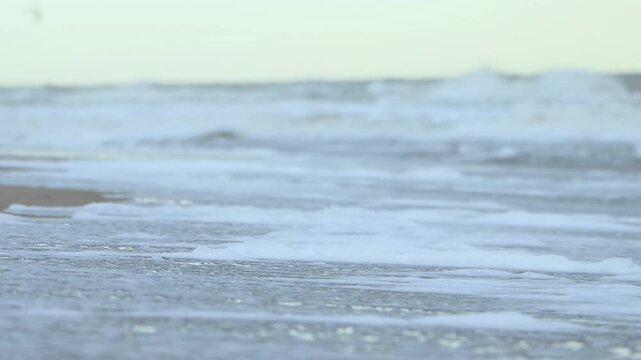 A beach with a large wave in the water. The water is white and the sand is brown in Carilo, Buenos Aires, Argentina, 4K Ultra HD 
